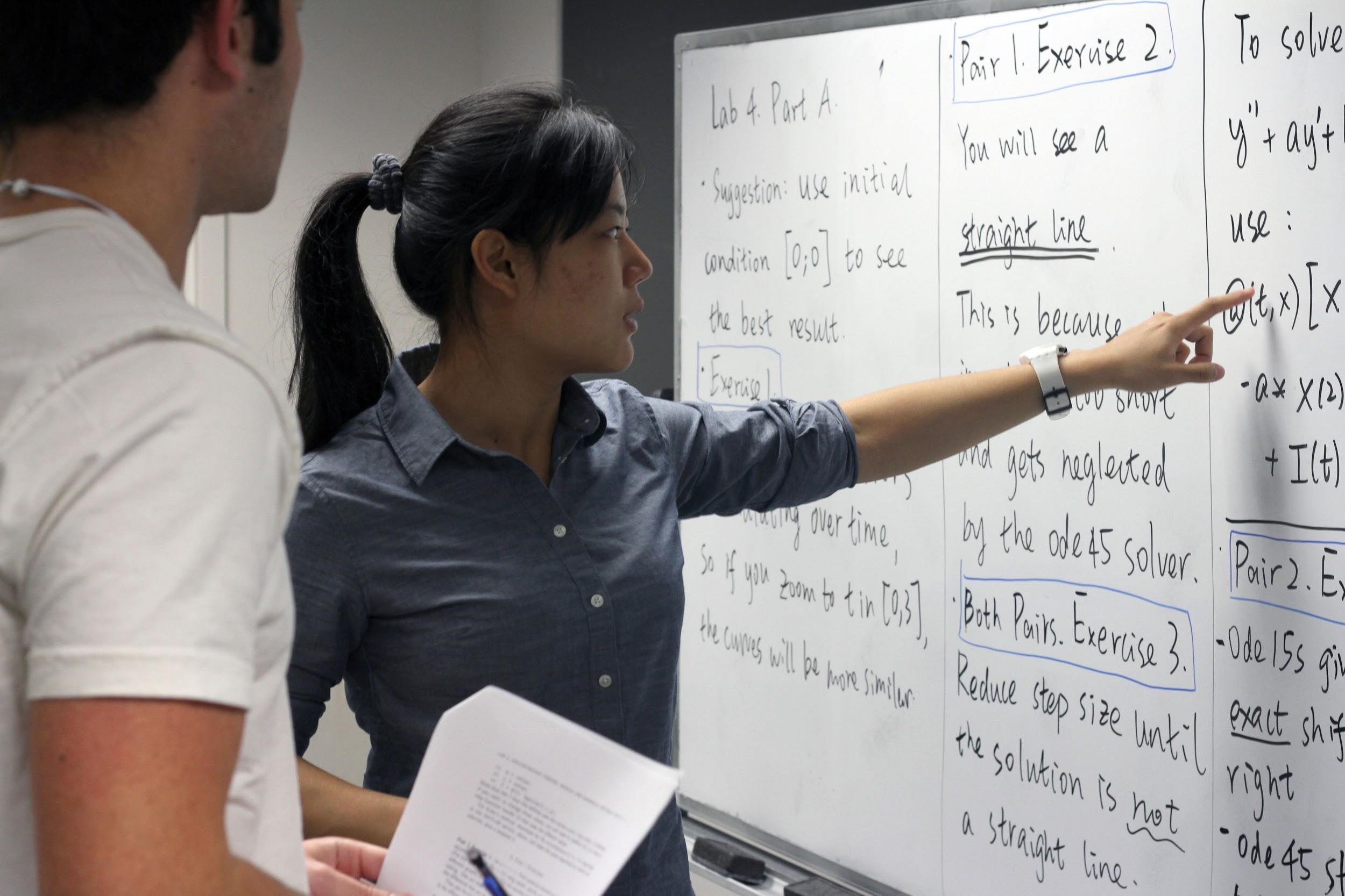 instructor pointing at a whiteboard