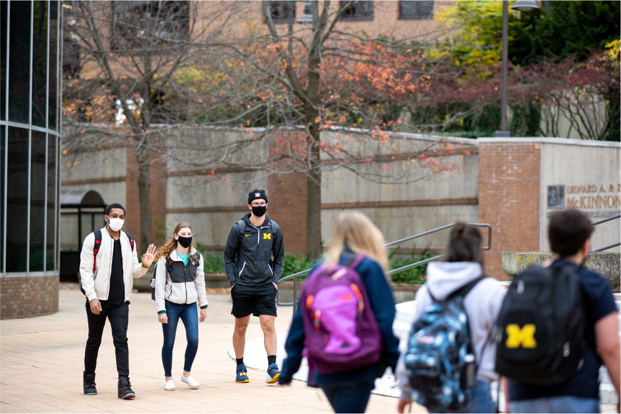 masked students walking on campus