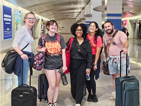A group stands with their luggage in an airport